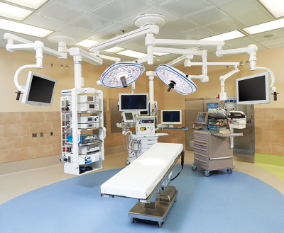 Operating room with Skytron surgical table, surgical lights, medical equipment boom arms, and equipment carrier